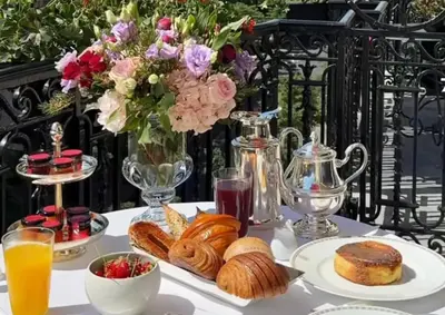 a table with plates of food and a vase of flowers at Hummingbird Haven Bed & Breakfast Luxury Suite With Terrace & Seasonal Lake Views Located in Historic Old Town Niagara-On-The-Lake in Niagara on the Lake