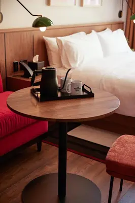 a coffee table with two cups on it next to a bed at The Postmark Hotel in Newmarket