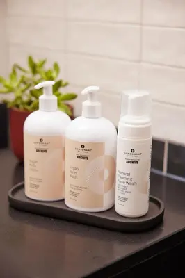 three bottles of moisturizers are sitting on a tray at The Postmark Hotel in Newmarket