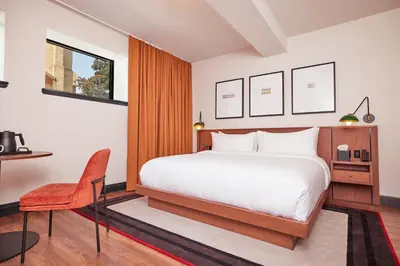 a bedroom with a bed and a desk and a chair at The Postmark Hotel in Newmarket