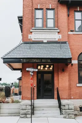 a red brick building with a stop sign in front of it at The Postmark Hotel in Newmarket