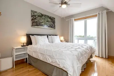 a bedroom with a large bed with a ceiling fan at Muskoka Lakeshore Cottage Bliss in Gravenhurst