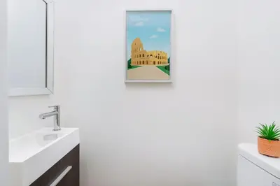 a bathroom with a framed picture of a building at Hidden Gem - 3 BR Steps to Little Italy and UofT in Toronto