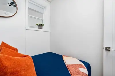 a room with an orange chair and a window at Hidden Gem - 3 BR Steps to Little Italy and UofT in Toronto