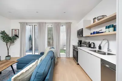 a living room with a blue couch in a kitchen at Hidden Gem - 3 BR Steps to Little Italy and UofT in Toronto