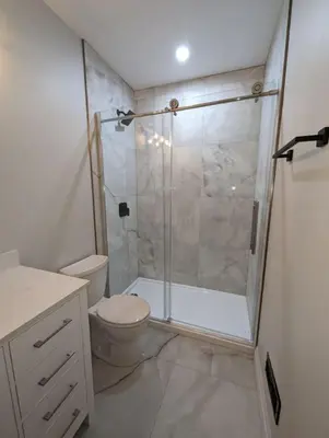 a bathroom with a toilet and a glass shower at 2BR 1 king 1 Queen with parking 3 GBPS internet in Kitchener