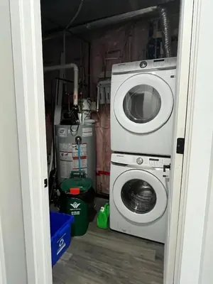 a washing machine and a washer in a garage at 2BR 1 king 1 Queen with parking 3 GBPS internet in Kitchener