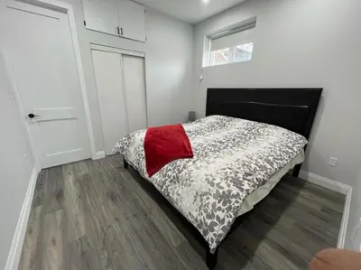 a small bedroom with a bed and a door at 2BR 1 king 1 Queen with parking 3 GBPS internet in Kitchener