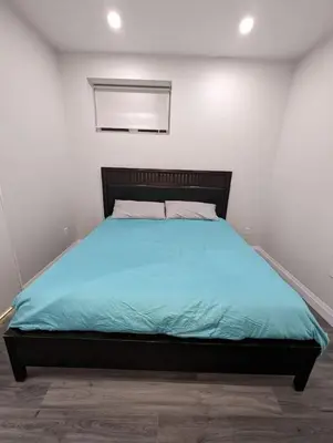 a bedroom with a large bed with blue sheets at 2BR 1 king 1 Queen with parking 3 GBPS internet in Kitchener