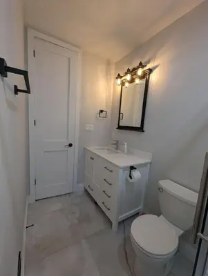 a bathroom with a toilet and a sink and a mirror at 2BR 1 king 1 Queen with parking 3 GBPS internet in Kitchener
