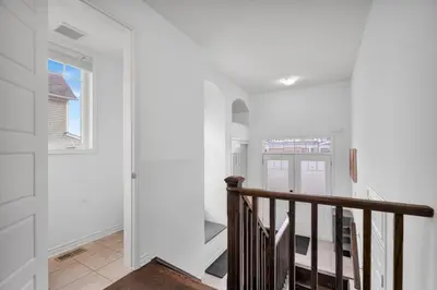 a white hallway with a staircase and a window at 4BR 2 king 3 Queen 6 beds in total 3 GBPS Wi-Fi in Kitchener