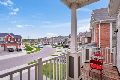 a balcony with a red chair and a street at 4BR 2 king 3 Queen 6 beds in total 3 GBPS Wi-Fi in Kitchener