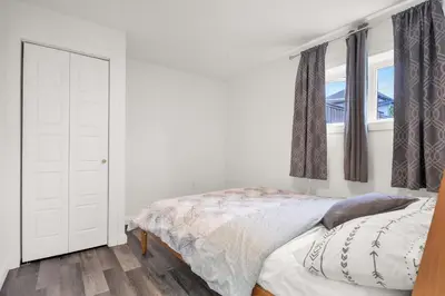 a white bedroom with a bed and a window at 4BR 2 king 3 Queen 6 beds in total 3 GBPS Wi-Fi in Kitchener