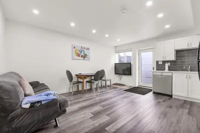 a living room with a couch and a table and a kitchen at Modern 2BR Duplex 3.0 GBPS internet with Parking in Kitchener