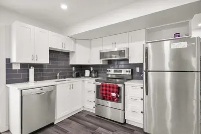 a kitchen with white cabinets and a stainless steel refrigerator at Modern 2BR Duplex 3.0 GBPS internet with Parking in Kitchener