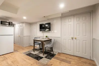 a kitchen with a table and a refrigerator at Modern, basement apartment, close to airport in Toronto