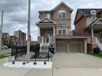 a brick house with a gate in front of it at Modern, basement apartment, close to airport in Toronto