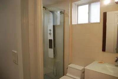 a bathroom with a shower and a toilet and a sink at Modern 2-BR Basement Apartment in Richmond Hill
