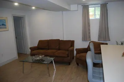 a living room with a couch and a table at Modern 2-BR Basement Apartment in Richmond Hill