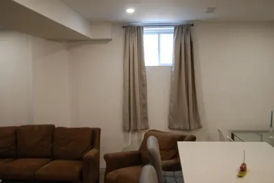 a living room with two chairs and a window at Modern 2-BR Basement Apartment in Richmond Hill