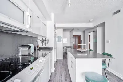 a kitchen with white cabinets and a counter top at Designer 2BR Downtown Condo, Rogers Center in Toronto