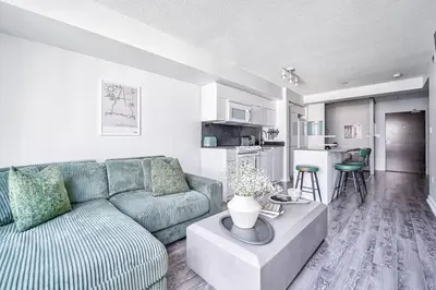 a living room with a couch and a table at Designer 2BR Downtown Condo, Rogers Center in Toronto