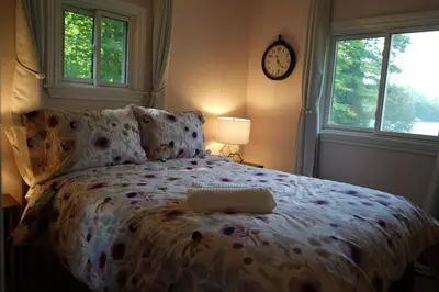 a bedroom with a bed and a clock on the wall at Mary Lake Sunset Lodge in Port Sydney