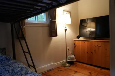 a bedroom with a bunk bed with a lamp and a television at Mary Lake Sunset Lodge in Port Sydney
