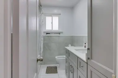 a white bathroom with a toilet and a sink at Beautiful house near Eglinton GO in Toronto