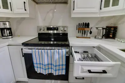 a kitchen with a black stove and white cabinets at Beautiful house near Eglinton GO in Toronto