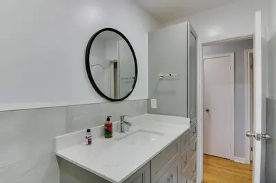 a white bathroom with a sink and a mirror at Beautiful house near Eglinton GO in Toronto