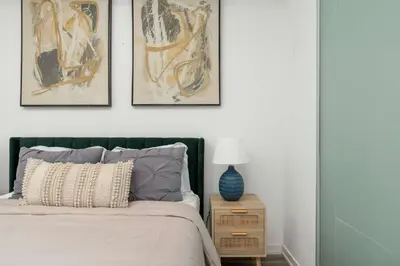a bedroom with a bed with three pictures on the wall at 1BD next to Queen St - most ideal location in Toronto