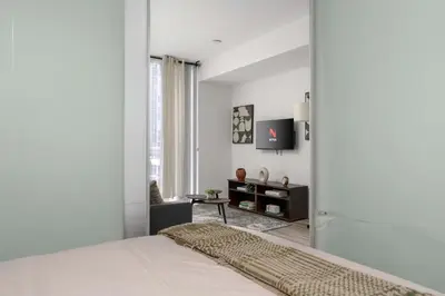 a white bedroom with a bed and a window at 1BD next to Queen St - most ideal location in Toronto