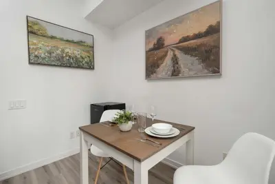 a dining room with a table and two paintings on the wall at 1BD next to Queen St - most ideal location in Toronto