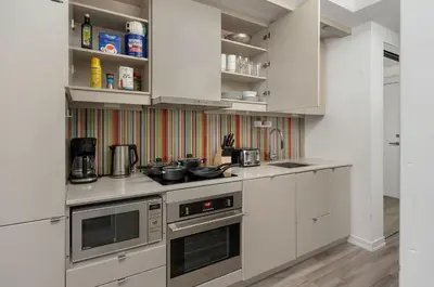a kitchen with white cabinets and a stove at 1BD next to Queen St - most ideal location in Toronto