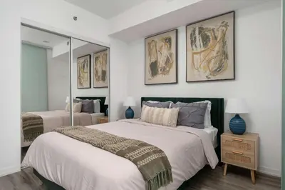 a bedroom with a large bed and two mirrors at 1BD next to Queen St - most ideal location in Toronto