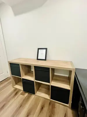 a wooden book shelf with a picture on top of it at Comfort Quarters in Guelph in Guelph