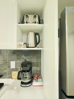 a coffee maker on a shelf in a kitchen at Comfort Quarters in Guelph in Guelph