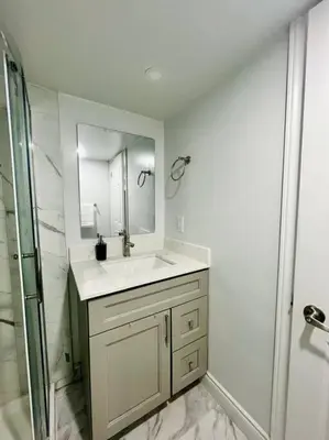 a white bathroom with a sink and a shower at Comfort Quarters in Guelph in Guelph
