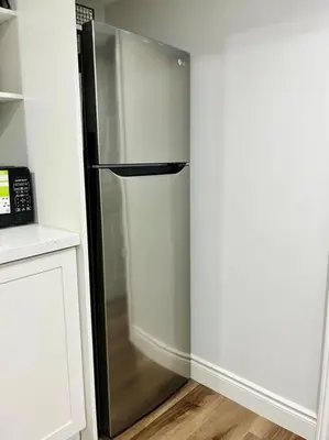 a stainless steel refrigerator in the corner of a kitchen at Comfort Quarters in Guelph in Guelph