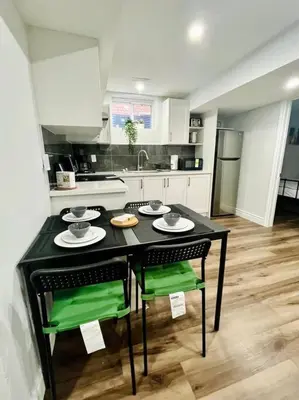 a kitchen with a black table and green chairs at Comfort Quarters in Guelph in Guelph
