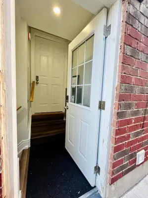 a hallway with a white door and a brick wall at Comfort Quarters in Guelph in Guelph