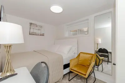 a white bedroom with a bed and a desk and a chair at South Oakville Bliss Haven Monthly Stays only in Oakville