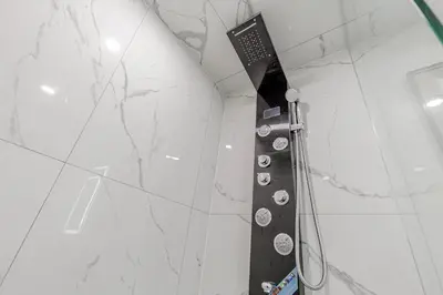 a shower with a black and white marble wall at South Oakville Bliss Haven Monthly Stays only in Oakville
