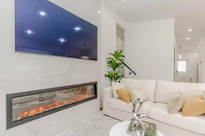 a living room with a white couch and a fireplace at South Oakville Bliss Haven Monthly Stays only in Oakville