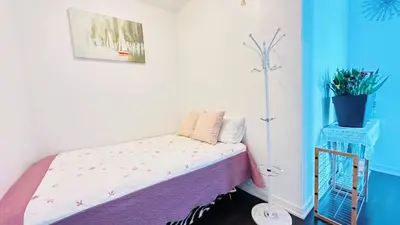 a small bedroom with a bed with a purple blanket at Superior Lakeview Luxury 3-Bedroom Suite on High Floor in Toronto