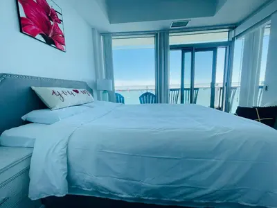 a bedroom with a bed with a view of the ocean at Superior Lakeview Luxury 3-Bedroom Suite on High Floor in Toronto