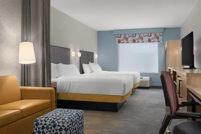 a hotel room with a large bed and a couch at Home2 Suites By Hilton Woodstock On in Woodstock