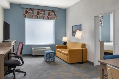 a hotel room with a chair and a bed at Home2 Suites By Hilton Woodstock On in Woodstock