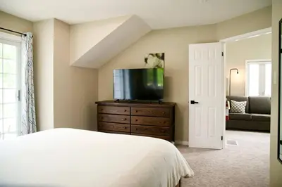 a bedroom with a bed and a tv on a dresser at Cozy, 4 Bedroom Chalet, 10 min walk to Village in Blue Mountains